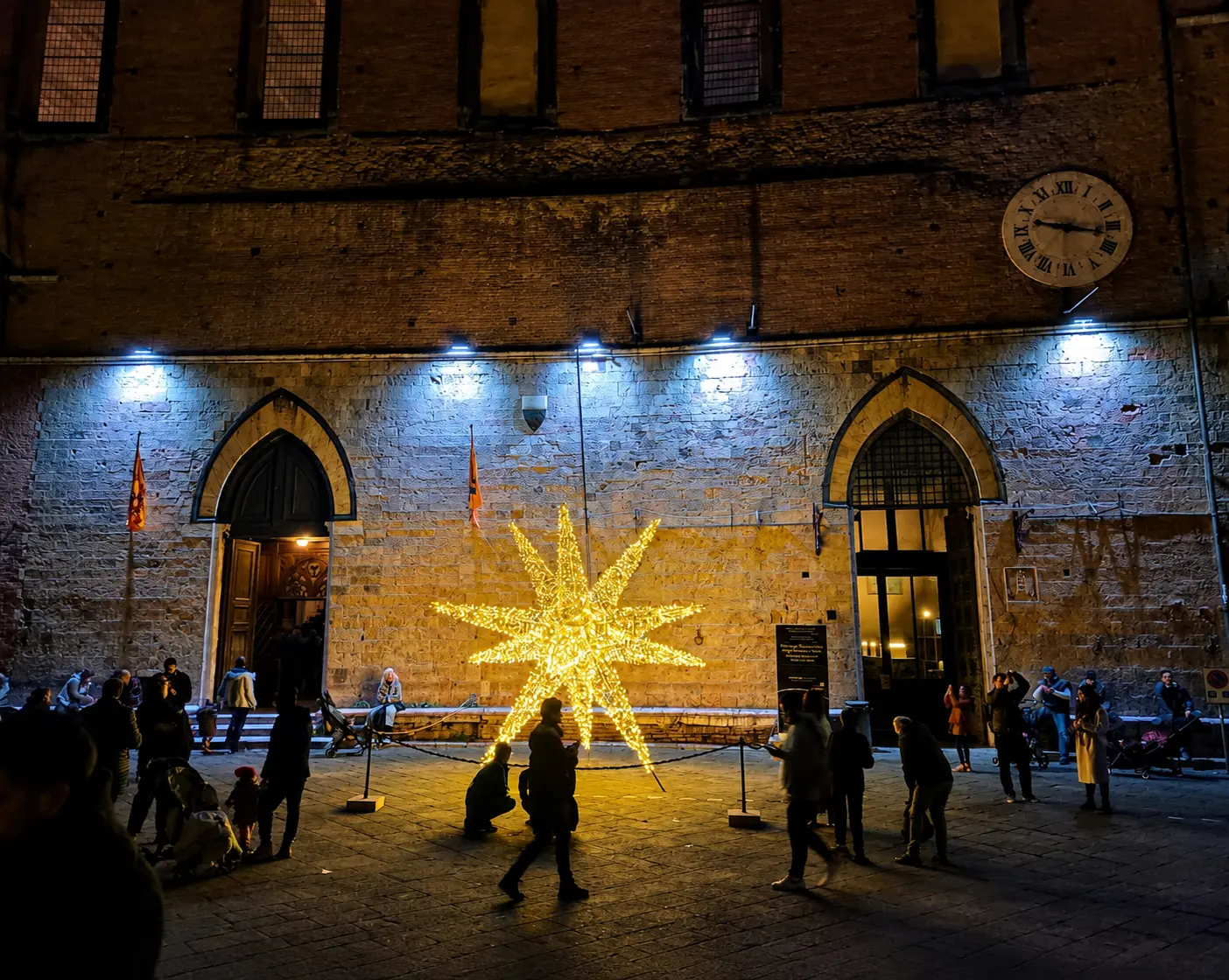 Stella luminosa installata in piazza, davanti a un palazzo storico di Siena